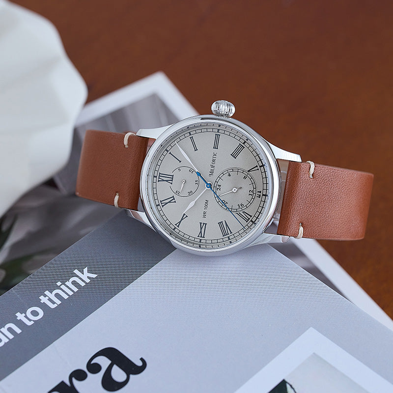 Gray quartz watch standing sideways on the edge of an English book